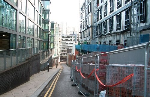 Builders' scaffolding and fencing filling the road opposite residential flats
