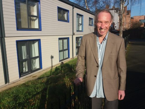 Cllr Douglas Johnson in front of retrofitted houses