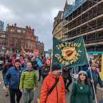 Green Party members marching with the banner