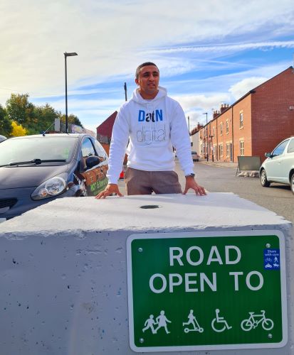 Cllr Maroof Raouf with "road open" signage