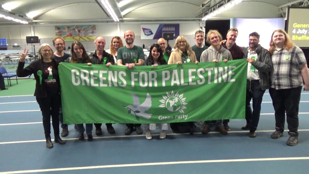 Green Party members with Greens for Palestine banner at the end of the General Election count 2024.