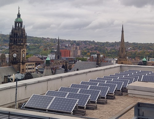 view of rooftop solar panels with Sheffield landmarks behind